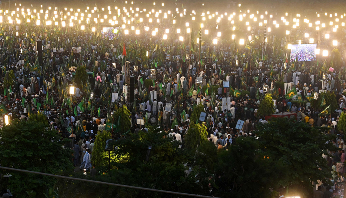 Supporters of former Prime Minister Nawaz Sharif await his arrival during an event held to welcome him at a park in Lahore on October 21, 2023. — AFP