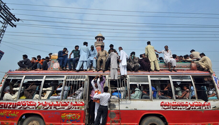 People while travelling on an overloaded bus in Lahore. — AFP/File