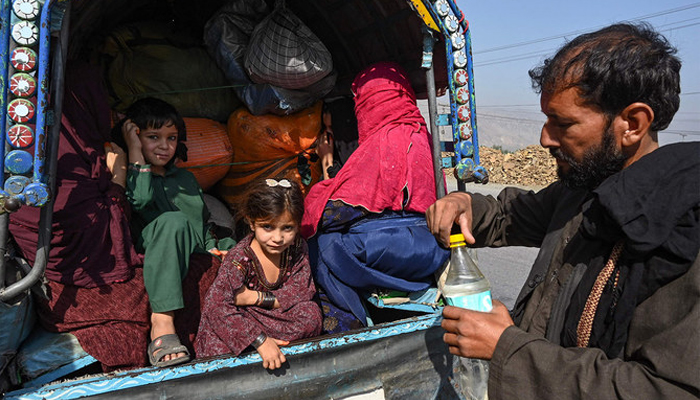 A family of Afghan nationals sit on a vehicle in Jamrud area of Khyber districton October 6, 2023, as they return to Afghanistan. — AFP