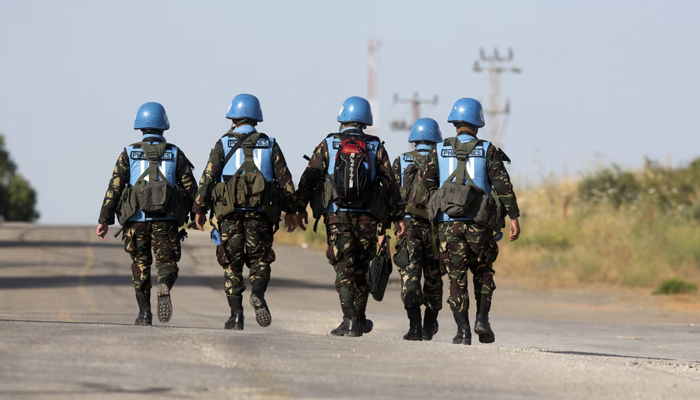 UN peacekeeping soldiers can be seen walking away. — AFP/File