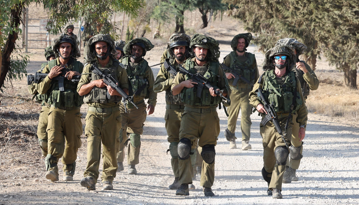 Israeli troops patrol at an undisclosed location along the border with the Gaza Strip on October 19, 2023. — AFP