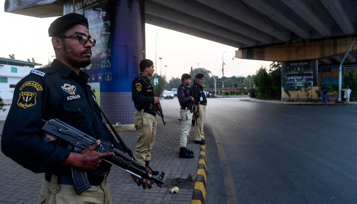 Police officials while standing guard on a road in Karachi. — AFP/File