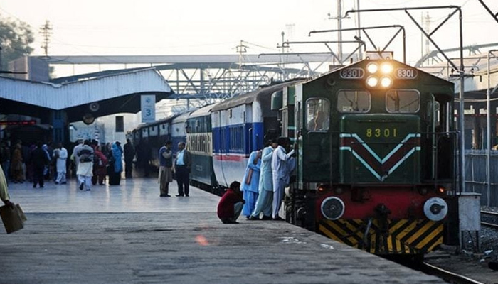 Passengers walk as a train leaves a station. — AFP/File