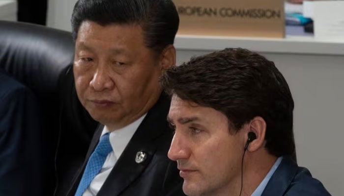 Prime Minister Justin Trudeau and Chinese President Xi Jinping listen to opening remarks at a plenary session at the G20 Summit in Osaka, Japan on June 28, 2019. GAC says the PRC targeted Trudeau and other MPs with an online propaganda campaign. (The Canadian Press)