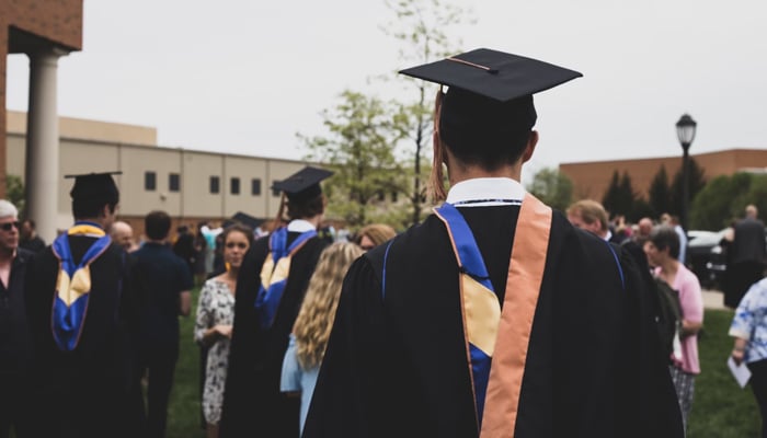A representational image shows a person wearing a convocation dress in an educational institution. — Unsplash/File
