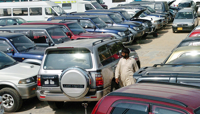 A Pakistani employee of a car showroom walks amidst new cars displayed at an auto dealer center in Karachi. — AFP/File