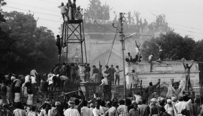 Hindu fundamentalists climb the dome of Babri Masjid in Ayodhya to demolish the structure on December 6, 1992. — CNN