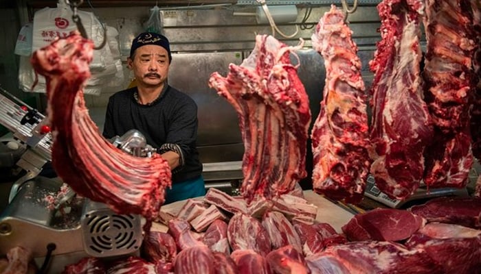 A halal butcher cuts meat in his stall at a market in Beijing on April 4, 2019. — AFP