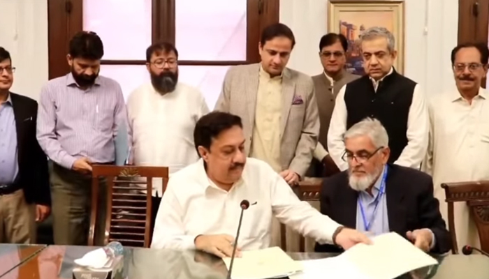 A ceremony of signing MoU between the KMC and Sindh government’s DEPD at the KMC HQs as Karachi Mayor Barrister Murtaza Wahab standing behind (c) looks down in this still taken from a video released on October 26, 2023. — Facebook/KMC