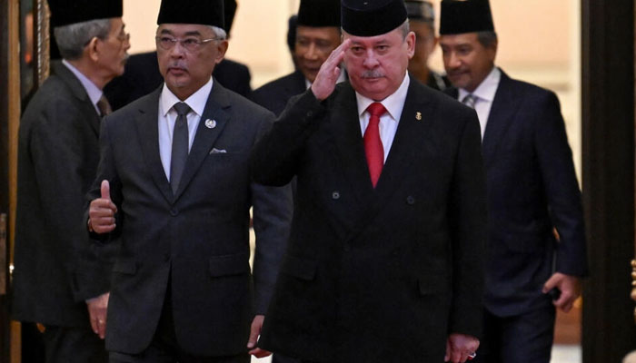 Malaysias King Sultan Abdullah Sultan Ahmad Shah (2nd L) and Sultan Ibrahim Sultan Iskandar of Johor (2nd R) walk together after the election for the next Malaysian king. AFP