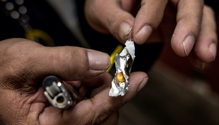 A representational image shows a motorbike taxi driver preparing drugs during an interview. — AFP/File