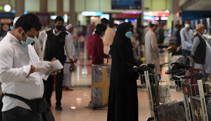 Pakistani nationals check in at the Dubai International Airport before leaving the Gulf Emirate on a flight back to their country, on May 7, 2020. — AFP