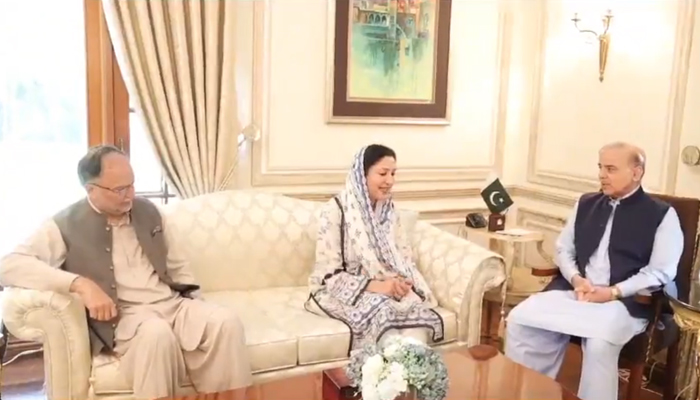 This screen grab taken from a video released on October 29, 2023, shows former PTI lawmaker Wajiha Qamar (c) meeting with the PMLN President Shehbaz Sharif (R) as PML-N leader Ahsan Iqbal (L) can also be seen. — X/@pmln_org