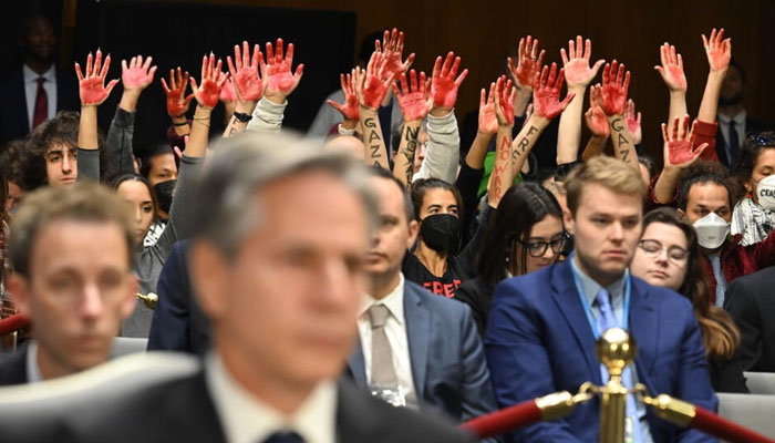Protesters raise their painted hands as US Secretary of State Antony Blinken testifies during a Senate Appropriations Committee hearing to examine the national security supplemental request, in Washingotn October 31, 2023. — AFP