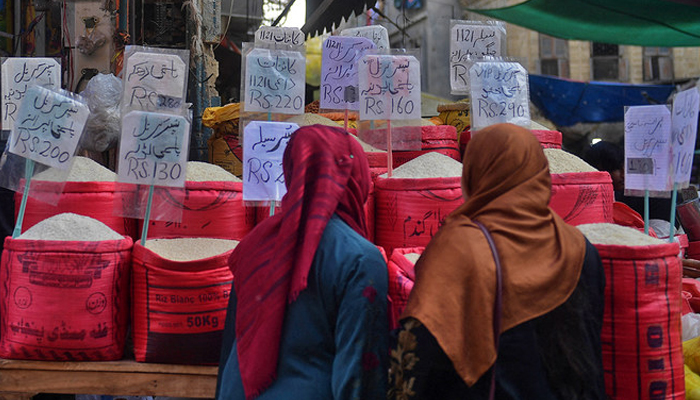 This picture on January 10, 2023, shows women checking rice prices at a main wholesale market in Karachi. — AFP