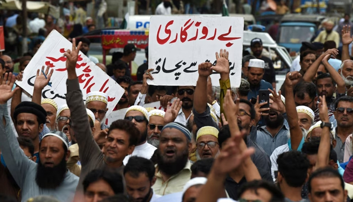 A trader holds a placard reading prevent unemployment from rising during a protest in Karachi, August 23, 2023, against the surge in petrol and electricity prices as Pakistan endures soaring inflation. — AFP
