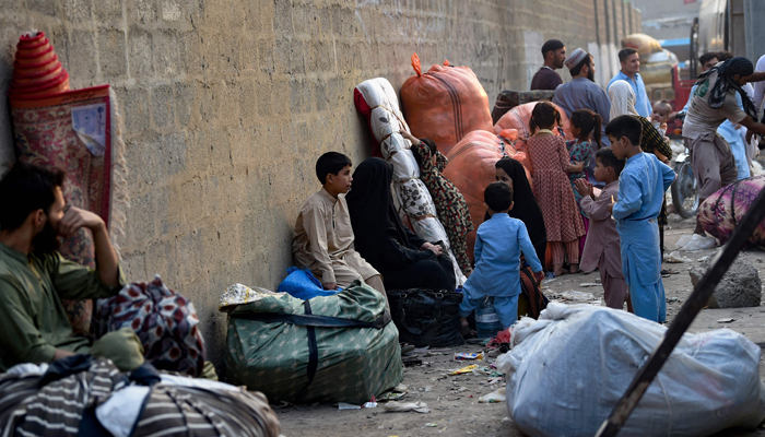 Refugees with their belongings wait at the Karachi bus terminal before their departure to Afghanistan on November 1, 2023. — AFP