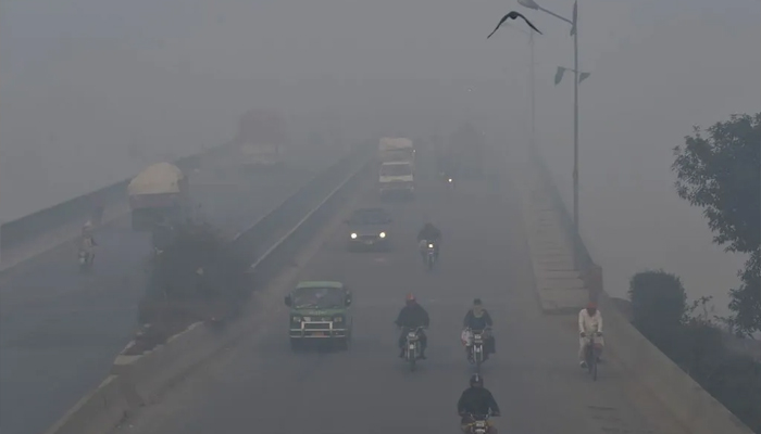 Commuters drive amid heavy smog conditions in Lahore. — AFP/File