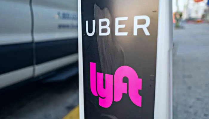Logos for ridesharing companies Uber and Lyft in downtown Los Angeles, California, October 24, 2018. — AFP File