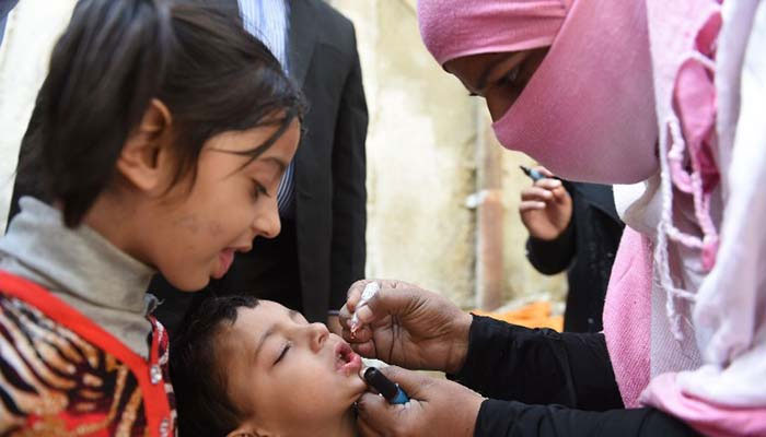A lady health workers administers anti-polio drops to a child. — APP File