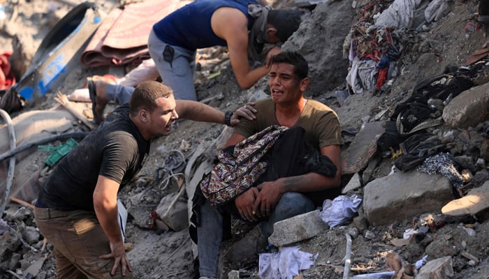 A man reacts as he holds the remains of his mother amid the rubble of a building destroyed in an Israeli strike on the Bureij refugee camp in the central Gaza Strip on November 2, 2023. — AFP