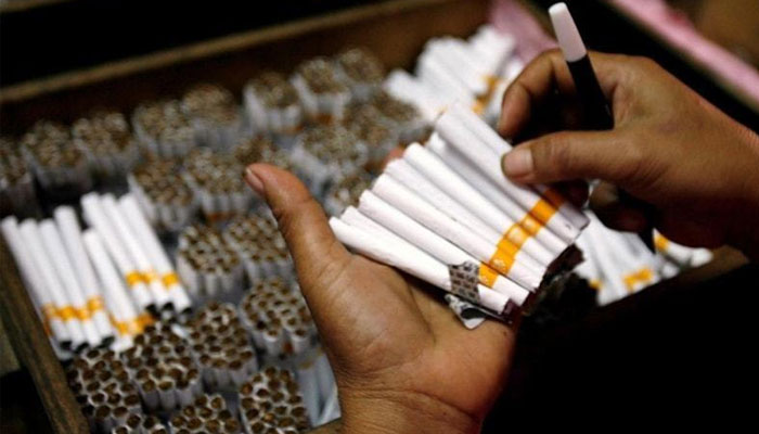 The image shows a tobacco company worker busy with cigarettes. —AFP File