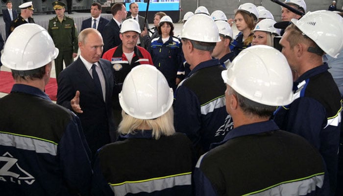 Russian President Vladimir Putin speaks with workers during a ceremony to mark the formal beginning of construction of Russian warships at Kerchs Zaliv shipyard on July 20, 2020. —AFP/File