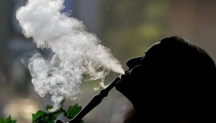 A representational image shows a lady smoking sheesha. — AFP/File