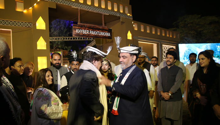 KP Minister of Information, Culture and Tourism, Mian Feroz Jamal Shah Kakakhel (R) presents a shawl to federal Minister for National Heritage and Culture Jamal Shah at KP Pavilion set up at ‘Lok Mela’ in Lok Virsa Islamabad in this image released on November 4, 2023. — Facebook/National Institute of Folk and Traditional Heritage-Lok Virsa لوک ورثہ