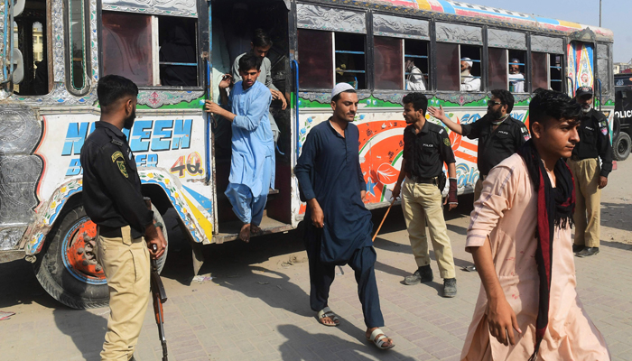 Detained Afghan refugees arrive at a police station in Karachi on November 2, 2023, following a police operation against illegal Afghan immigrants. — AFP