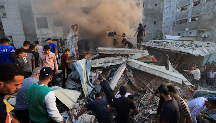 Palestinians search through the rubble of a collapsed building looking for survivors following a strike by the Israeli military on Khan Yunis in the southern Gaza Strip on November 4, 2023. — AFP