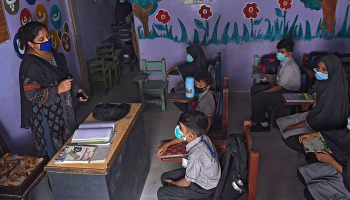 Students sit during a class listening to a teacher. — AFP/File