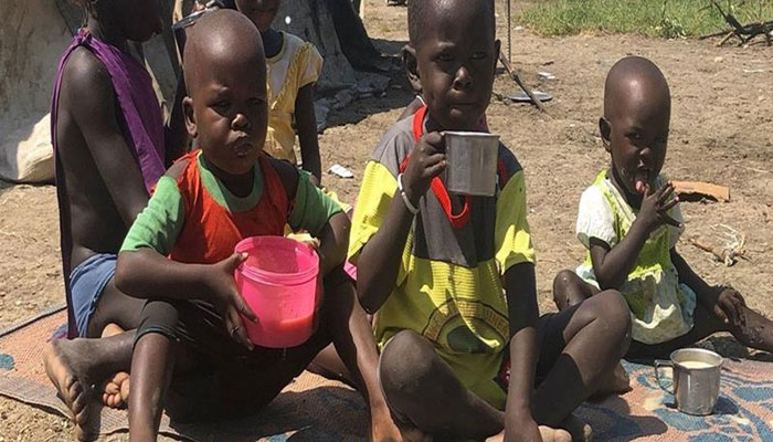 Children eat porridge their mother cooked with the food she received at a World Food Programme (WFP) distribution site in Pibor, South Sudan. — WFP