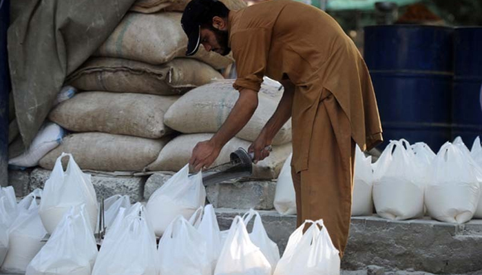 A man fills shopping bags with flour. — AFP/File