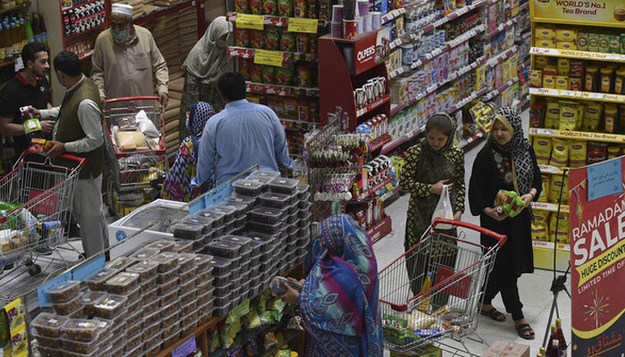 People buy grocery items at a store in Peshawar, Pakistan, on April 5, 2021. —AFP/File