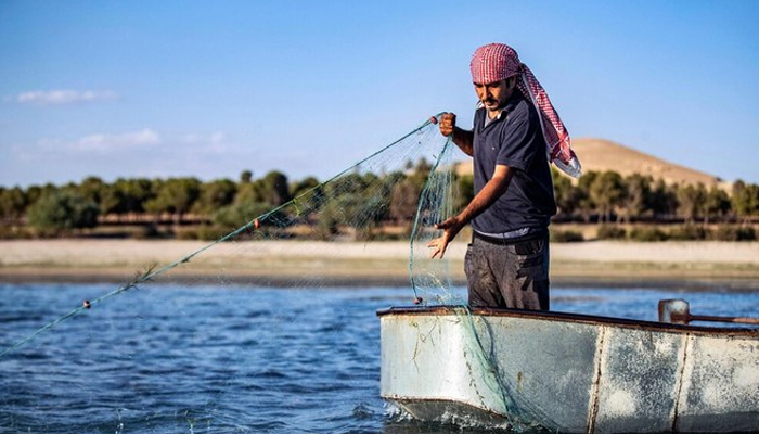 A representational image shows a fisherman pulling his net from Lake Assad in the village of Al-Tawayhinah, near the Tabqa dam in Syria’s Raqqa governorate on July 10, 2023. — AFP