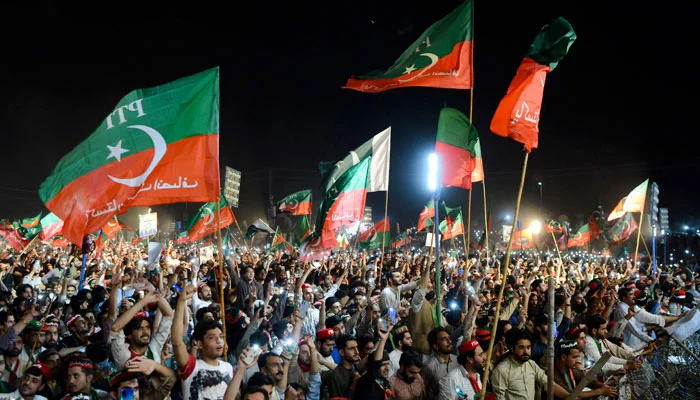 PTI workers hoist their party flags at a public gathering in this undated picture. — AFP/File