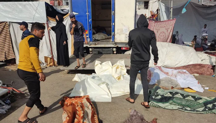People check the bodies of victims killed in a reported Israeli attack, as they lie on the ground in the vicinity of Gaza Citys Al-Shifa hospital compound on November 10, 2023. — AFP