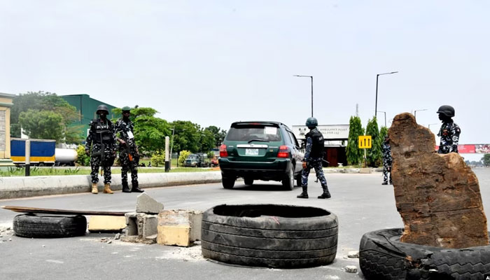 Police officers stand at a barricade on Lagos expressway as they enforce a restriction imposed on movement of motorists during local elections, in Lagos, on March 18, 2023. — AFP File