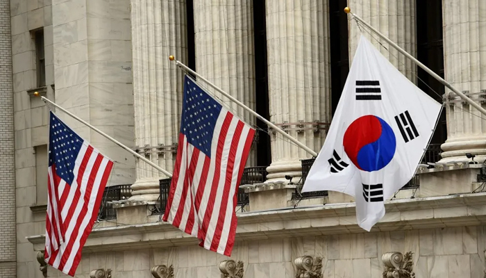 The South Korean flag (R) flies with US flags outside the New York Stock Exchange in New York. — AFP/File