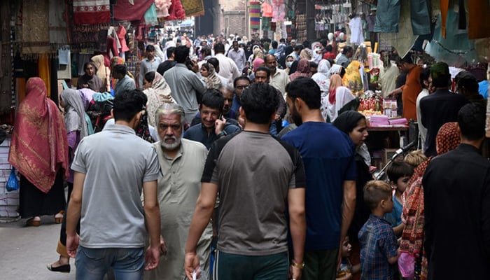 In this picture taken on April 16, 2023, people throng a market area in Lahore. — AFP