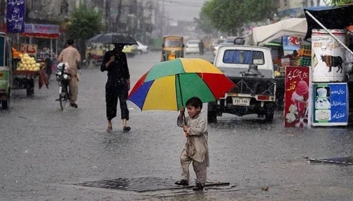 A child carries an umbrella as he walks on the road during rain. — AFP/File