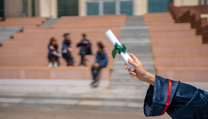This representational image shows a person holding a degree. — Unsplash/File
