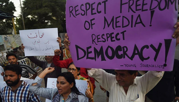 Pakistani journalists and civil society activists hold placards against the attack on a senior journalist of a local newspaper in Karachi on October 28, 2017. — AFP