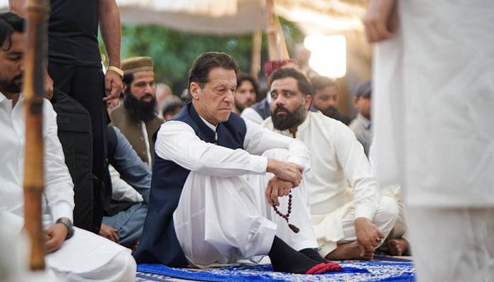 Former prime minister Imran Khan sits during a gathering with the party workers in Lahore in this image released on April 22, 2023. — Facebook/Imran Khan
