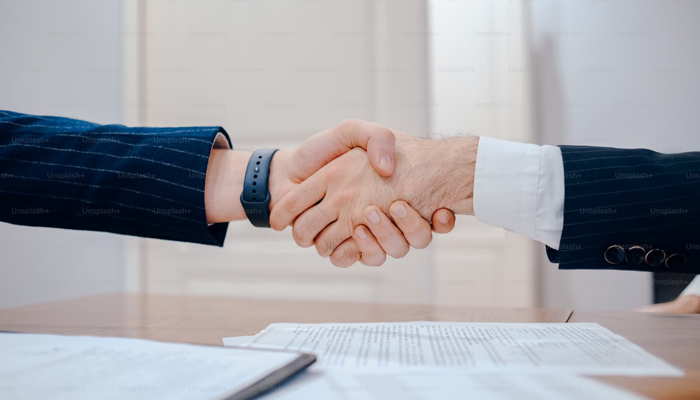 A representational image shows people shaking their hands after signing an agreement. — Unsplash/File