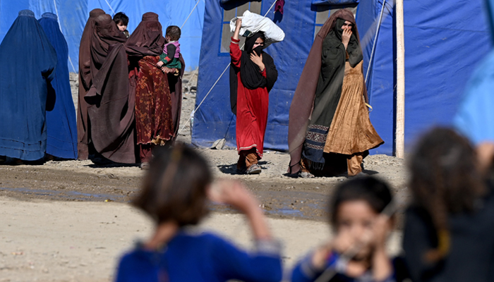 Afghan refugees walk through a makeshift camp upon their arrival from Pakistan, near the Torkham border in Nangarhar on November 12, 2023. — AFP