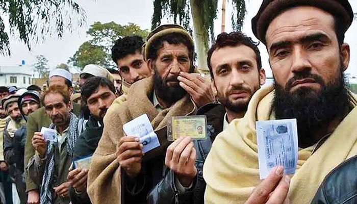 Afghan refugees seen showing their ID cards to the camera. AFP/File