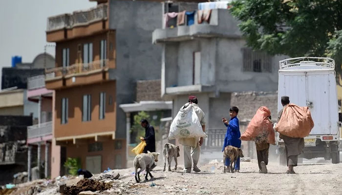 Pakistani rag-pickers search for recyclable items in Rawalpindi on May 23, 2017. — AFP