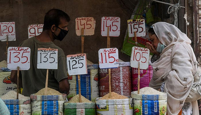 A woman checks the smell of rice at a market in Karachi on June 10, 2020. — AFP